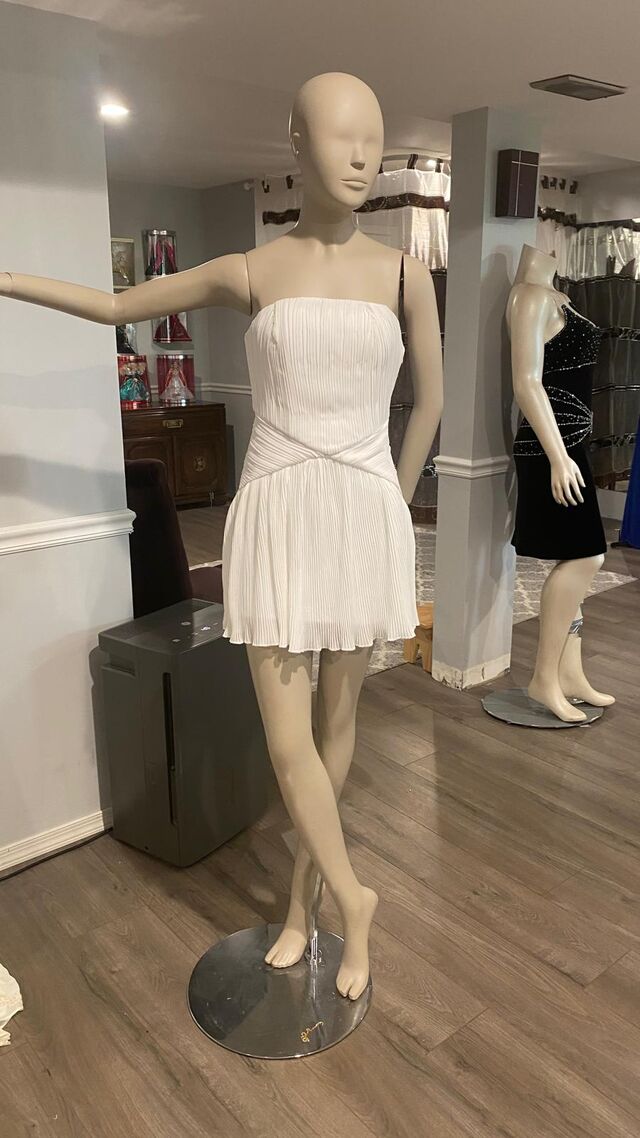 Inside the Farrah Couture boutique — pleated cocktail dress and beaded velvet gown on mannequins